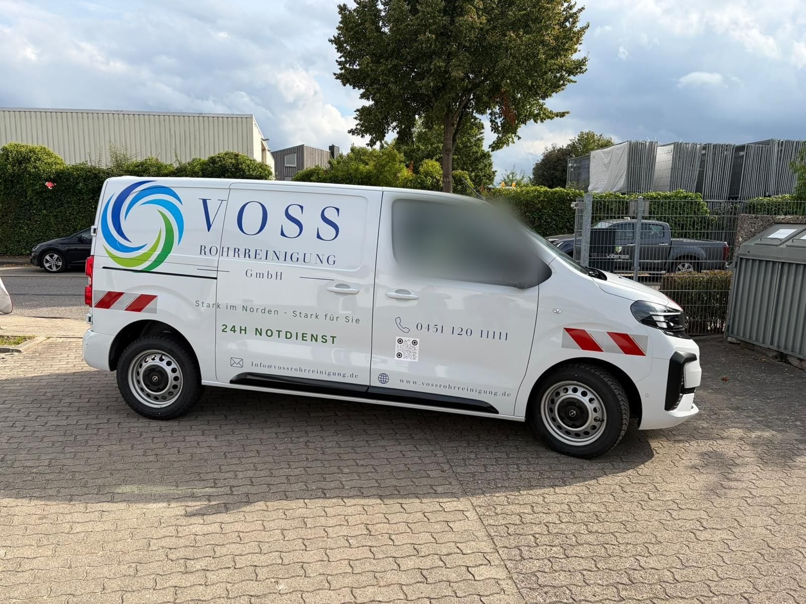Foliertes Fahrzeug der Voss Rohrreinigung GmbH mit Rufnummer und Internetadresse